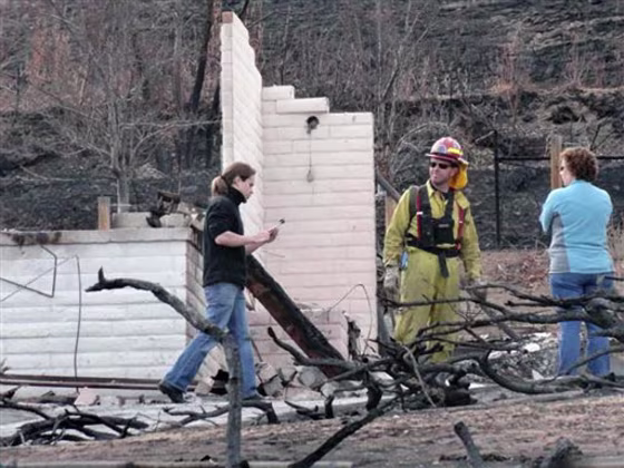 Austin Hardage, 23, left, returns Nov. 19&nbsp;to the charred rubble that used to be the home where he and his wife, Sarah Hardage, 22, lived in an upscale community in the Sierra foothills in southwest Reno, Nev. before a wildfire destroyed that home and 31 others early Friday.